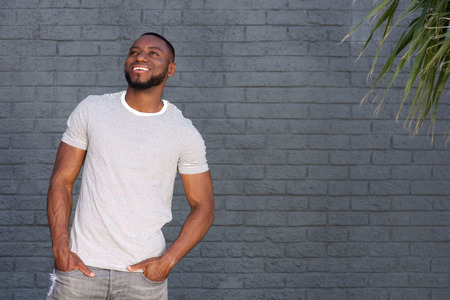 Portrait of smiling handsome man standing by wall outsideの写真素材