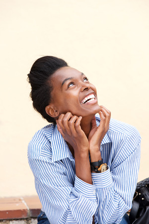Portrait of young woman smiling and looking upの写真素材