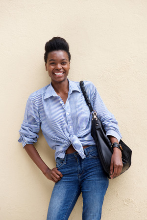 Portrait of smiling young black woman with handbagの写真素材