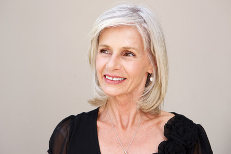 Close up portrait of smiling older woman thinking in black blouse