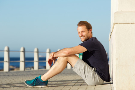 Side portrait of active middle age man sitting outside and smilingの写真素材