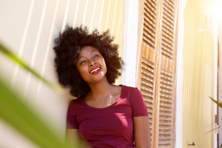 Close up portrait of happy woman standing outside houseの写真素材