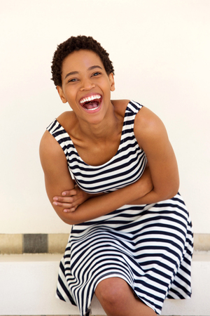 Portrait of laughing young black woman in striped dressの写真素材