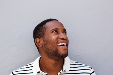 Close up portrait of happy african american man smiling against gray wallの写真素材