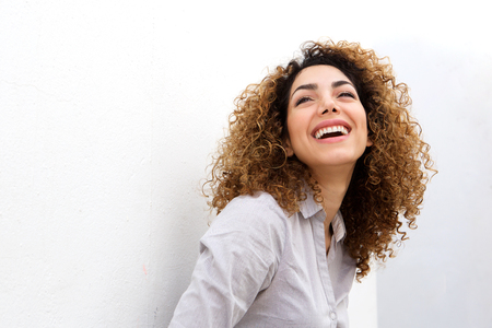 Portrait of smiling young woman smiling against white backgroundの写真素材