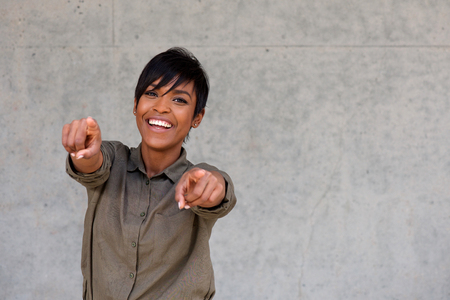 Portrait of cheerful young black woman pointing fingers with copy spaceの写真素材