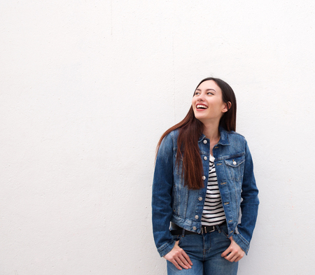 Portrait of laughing woman standing in denim jacketの写真素材