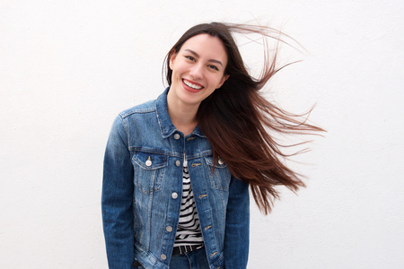 Portrait of happy woman in denim jacket with long hair blowingの写真素材