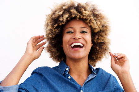 Close up portrait of african american female laughing against white wallの写真素材