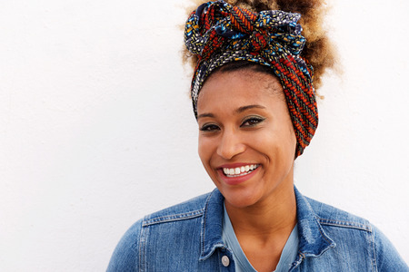 Close up portrait of young afro american female smiling against white backgroundの写真素材