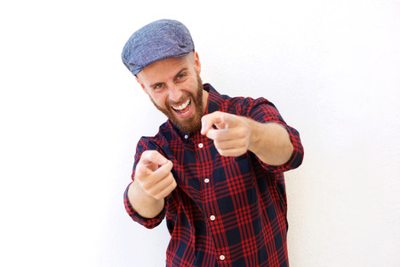 Portrait of happy young man laughing and pointing fingersの写真素材