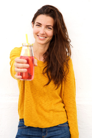 Portrait of smiling female holding a glass of juiceの写真素材