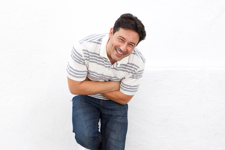 Portrait of older man standing isolated on white background and laughingの写真素材