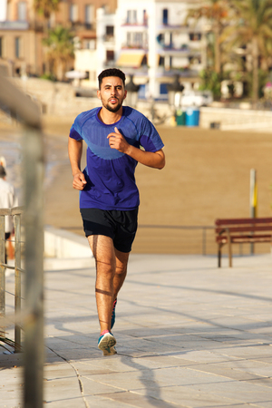 Full length portrait of young man running outdoorsの写真素材