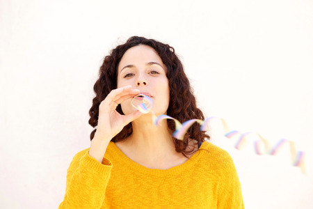 Close up portrait of attractive young woman blowing confettiの写真素材