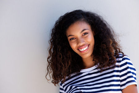 Close up horizontal portrait of happy young african woman smiling against white backgroundの写真素材