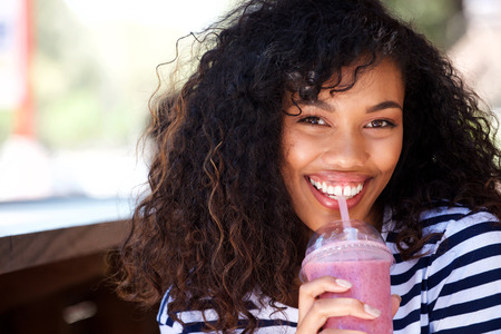 Close up portrait of beautiful young woman drinking smoothieの写真素材