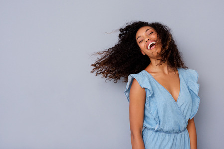 Portrait of cheerful young african american woman with curly hair laughing の写真素材