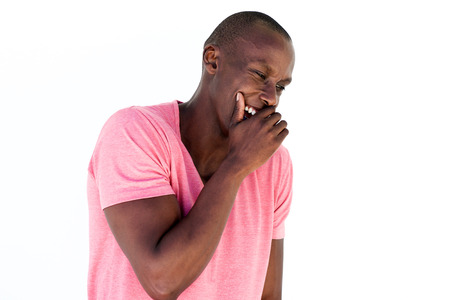Portrait of young african american man laughing with hand covering mouthの写真素材