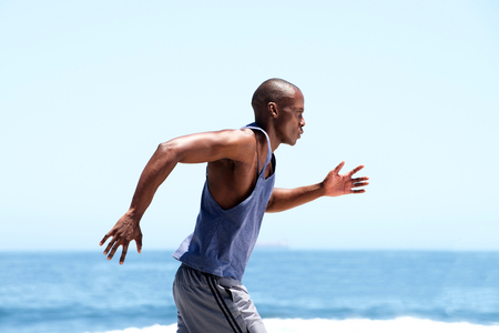 Side of african american male runner outside by sea