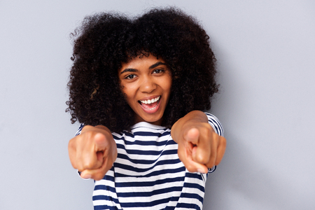 Close up portrait of happy young black woman smiling and pointing fingersの写真素材