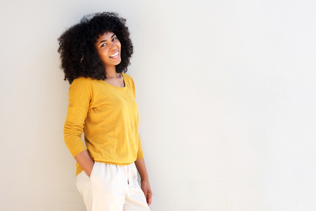Portrait of beautiful smiling black woman against white wall with copy spaceの写真素材
