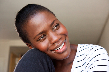 Close up portrait of happy african woman sitting at home and smilingの写真素材