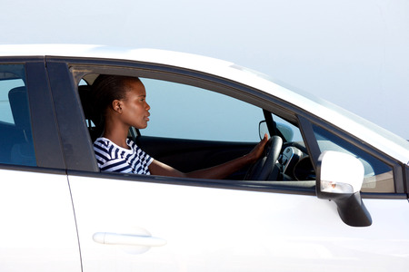 Side portrait of young african woman driving carの写真素材