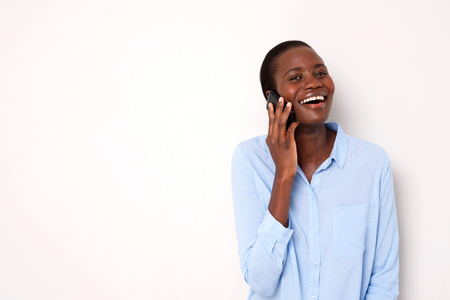 Portrait of african woman talking on mobile phone and smiling on white backgroundの写真素材