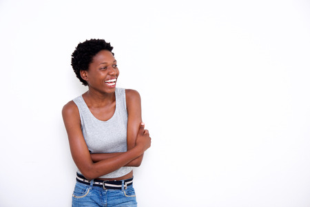 Portrait of african woman standing with arms crossed and laughing on white background