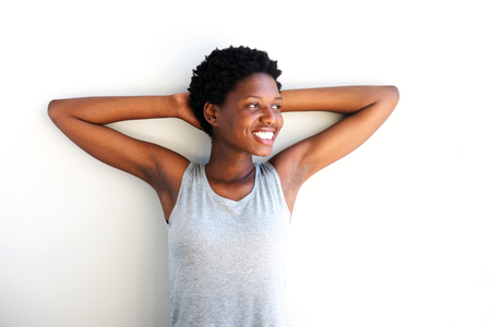 Portrait of relaxed african woman with hands behind head and looking away on white backgroundの写真素材