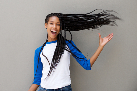 Portrait of attractive young african american woman with long braided hair on gray backgroundの写真素材