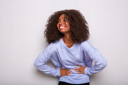 Portrait of cheerful young african woman laughing on white background