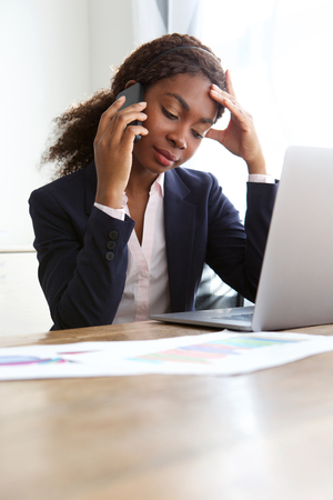 Portrait of young business woman at work making a phone callの写真素材