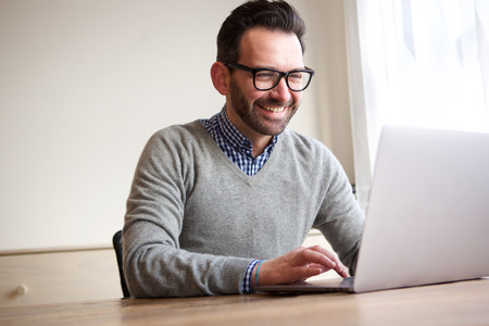 Portrait of happy businessman working with laptop computerの写真素材