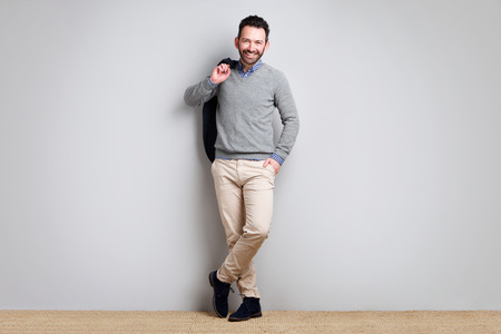 Full body portrait of happy businessman against gray backgroundの写真素材