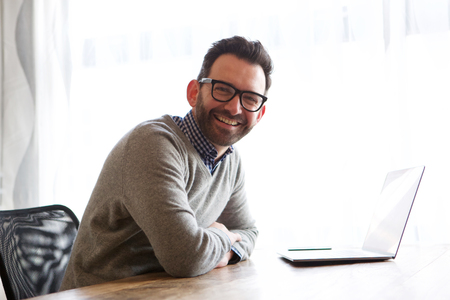 Portrait of happy businessman smiling with laptopの写真素材