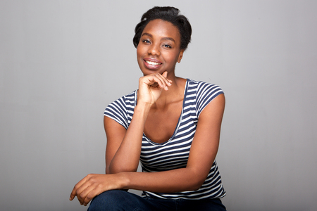 Portrait of beautiful woman sitting with hand on chinの写真素材