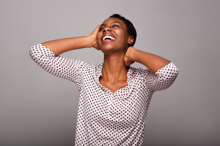 Portrait of beautiful woman laughing with hands by faceの写真素材
