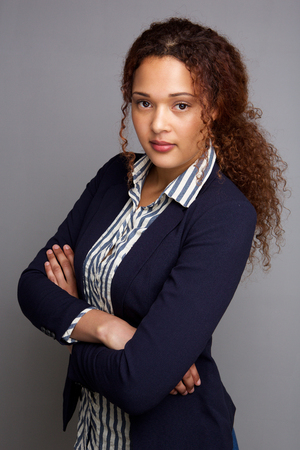 Portrait of serious young business woman against gray backgroundの写真素材