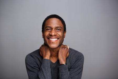 Portrait of cheerful african american guy against gray backgroundの写真素材