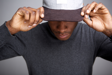 Close up portrait of cool african american male model with hat looking down