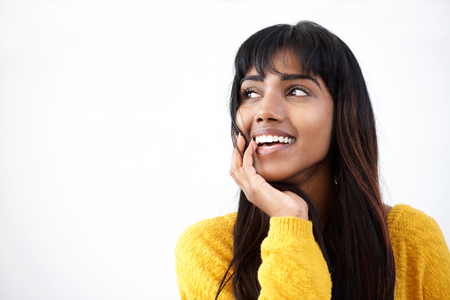 Close up portrait of smiling young Indian woman with hand by mouthの写真素材