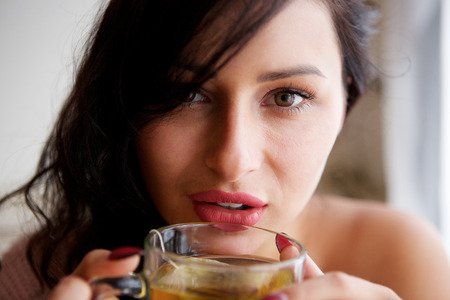 Close up portrait of woman at home with healthy warm tea