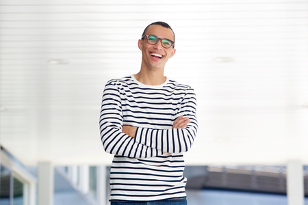 Portrait of confident young man with glasses smiling outsideの写真素材