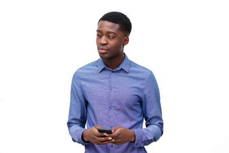 Portrait of young african american man in blue shirt holding cellphone against isolated white...