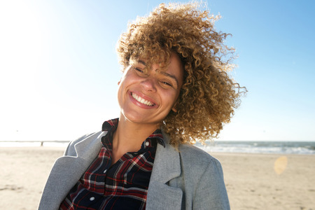 Close up portrait of beautiful african american woman smiling at the beach