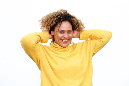 Portrait of happy young african american woman laughing against white background with arms behind headの写真素材