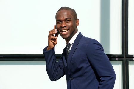 Portrait of corporate african american businessman talking cellphone outdoorsの写真素材