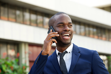 Close up portrait of black corporate businessman talking with mobile phone in the cityの写真素材